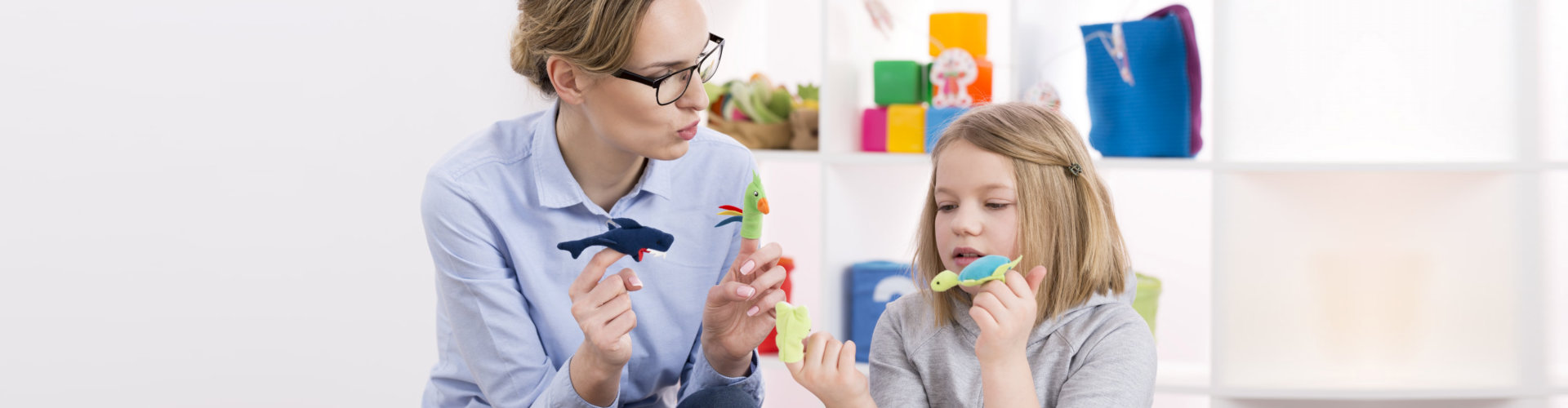 teacher using colorful toys during play therapy with child